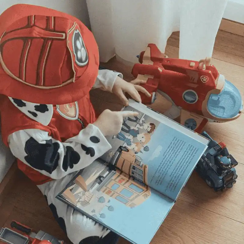 Junge liest ein Buch in Paw-Patrol Kostüm