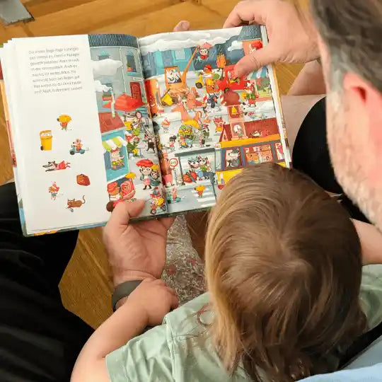 Kind und Vater lesen das Winterwimmelbuch