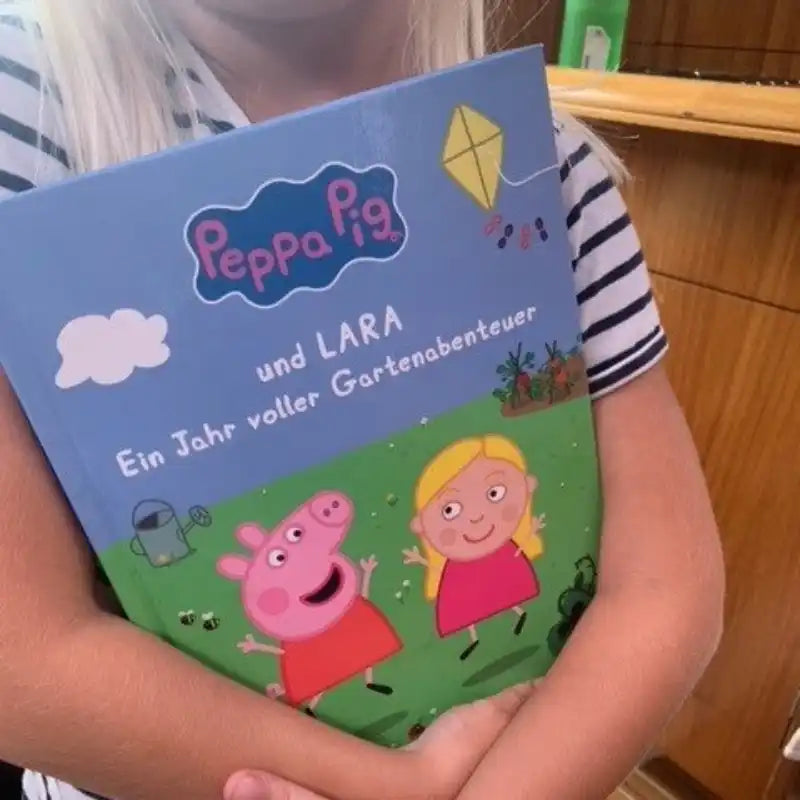 Kind mit Peppa-Buch in der Hand.